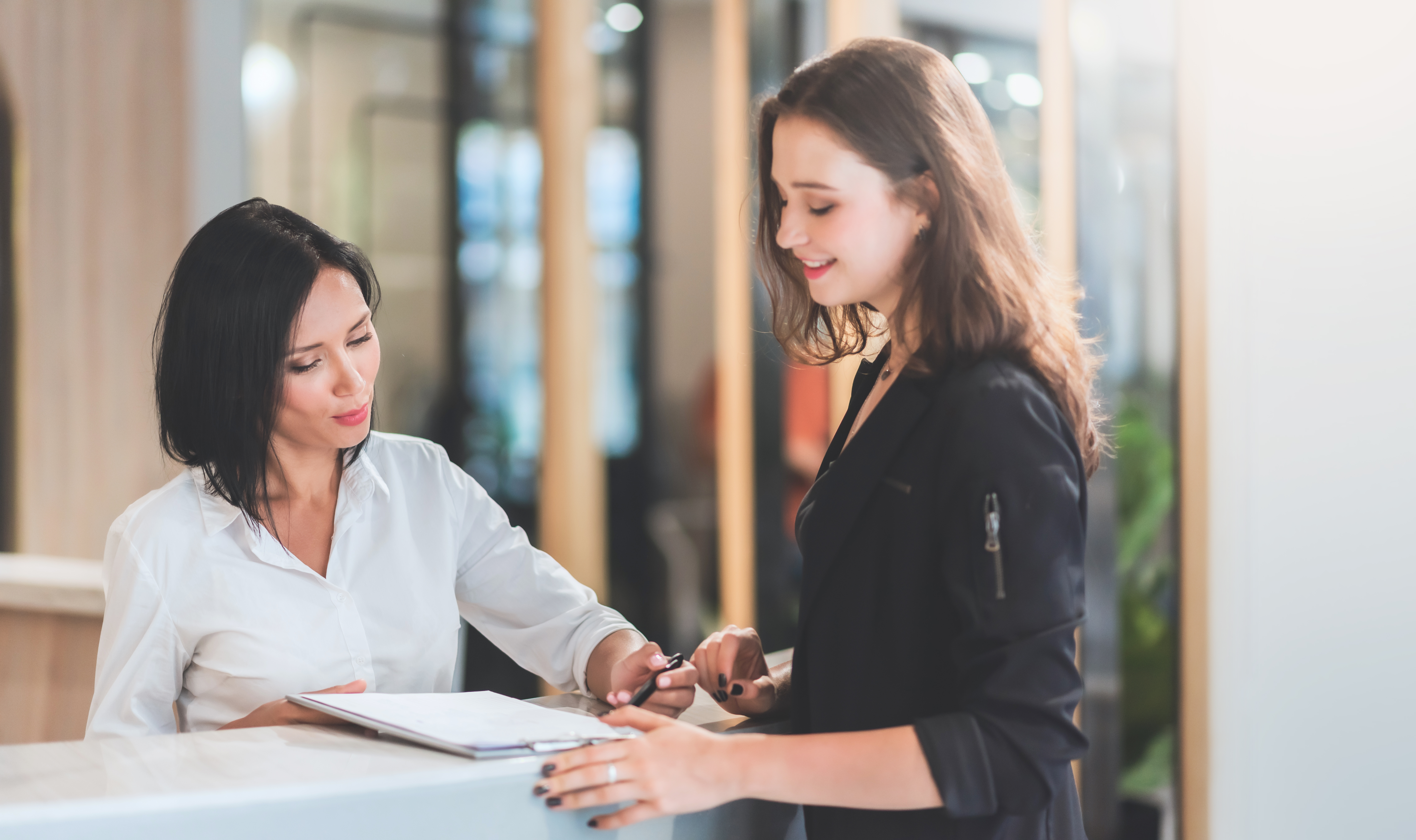 A school administrator assists a parent with paperwork