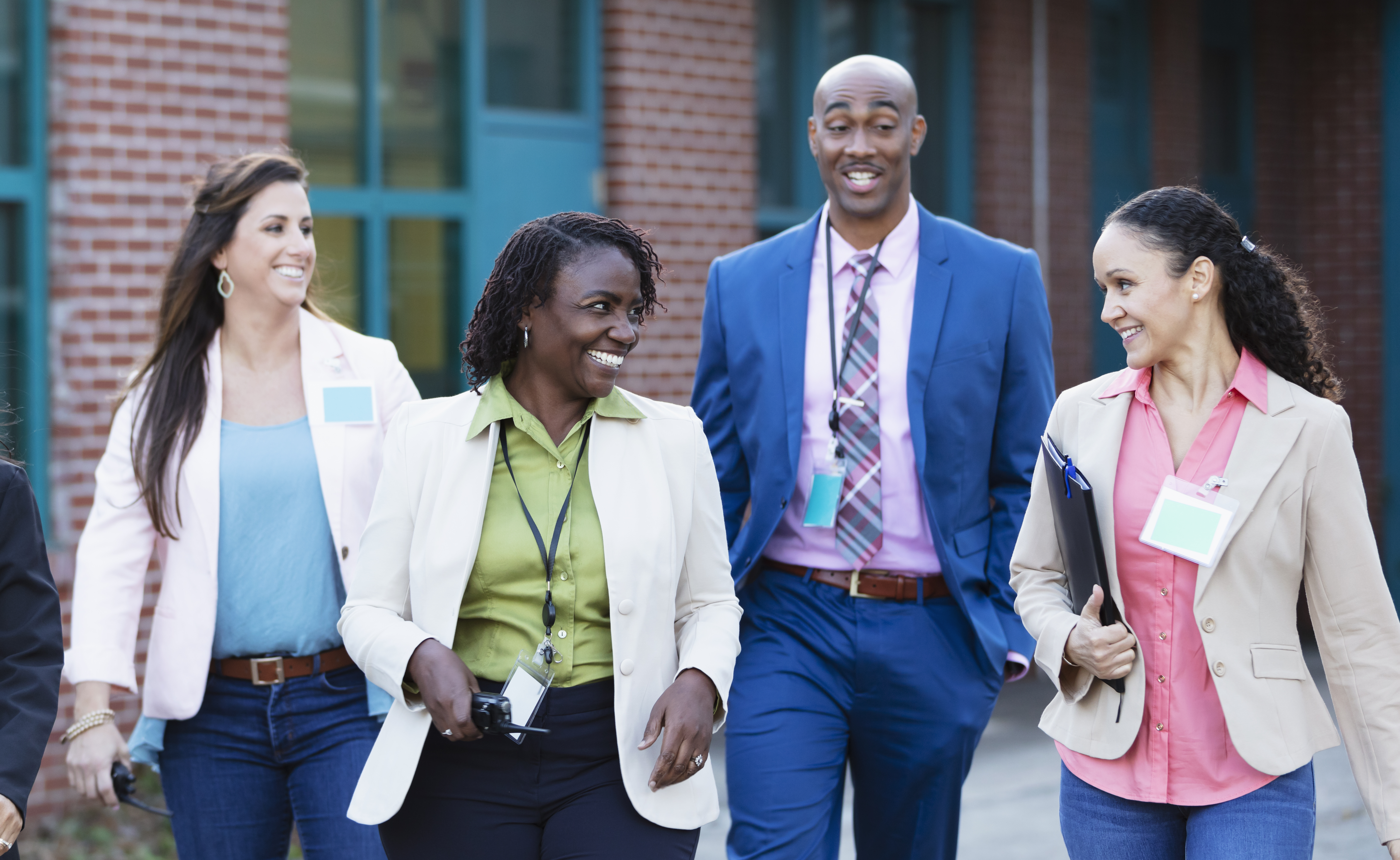 A diverse group of school administrators walking around the school campus