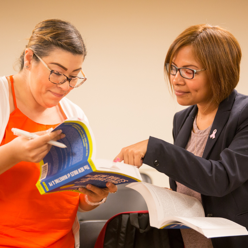 Two women looking and reading two books