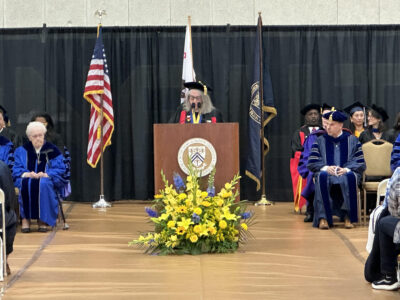 A professor gives a speech at a college graduation ceremony.